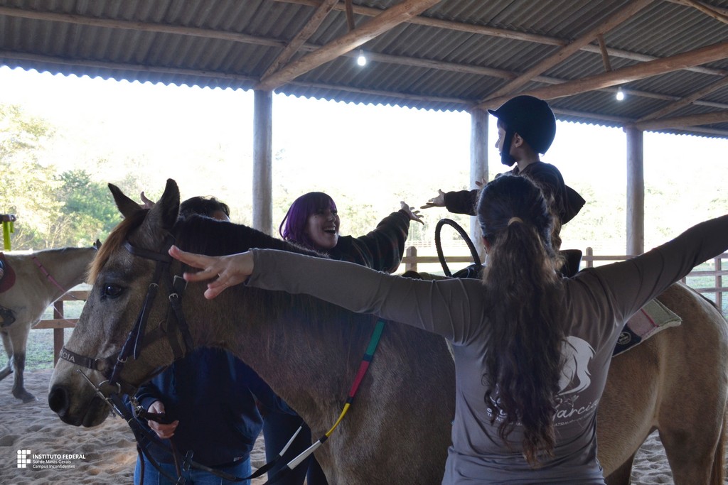 Instrutores de Equoterapia do Campus Inconfidentes orientam paciente sobre o cavalo. (Foto: ASCOM)