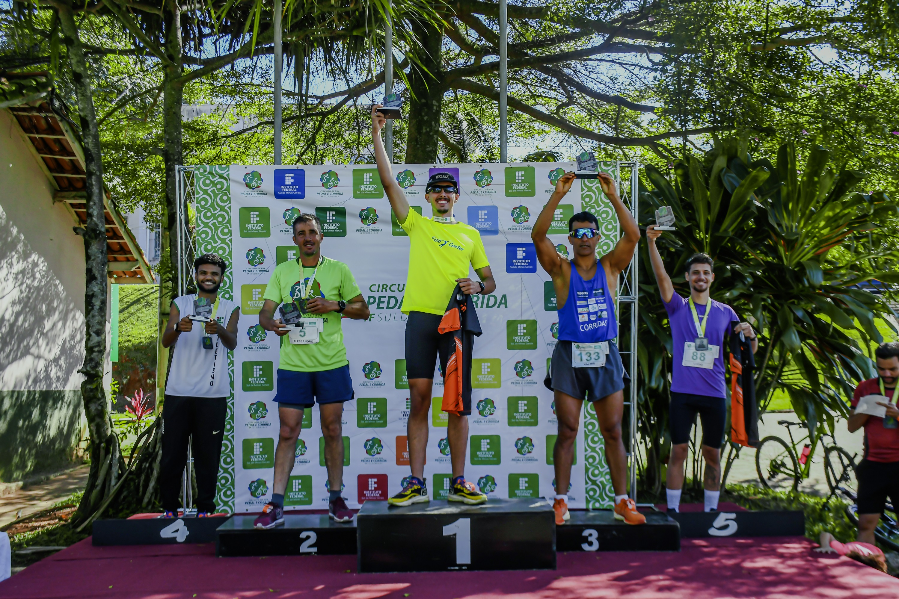 Atletas da modalidade "Corrida Masculina" recebem troféu, no podium montado na Fazenda-Escola (